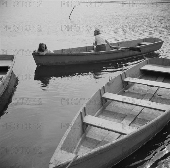 A camper returning a boat to the dock at Camp Gaylord White, Arden, New York, 1943. Creator: Gordon Parks.