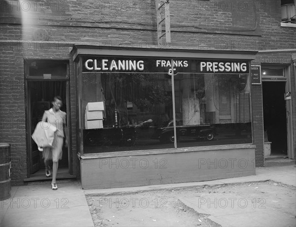 Possibly: A tailor in Frank's cleaning and pressing establishment checking..., Washington, DC, 1942. Creator: Gordon Parks.