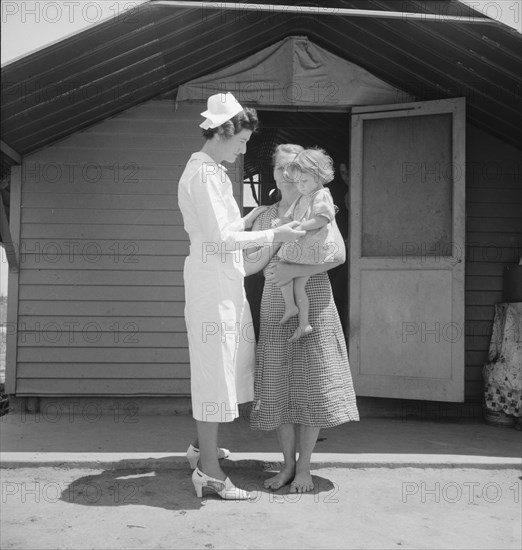 Resident nurse come to visit family, FSA camp, Farmersville, Tulare County, 1939. Creator: Dorothea Lange.