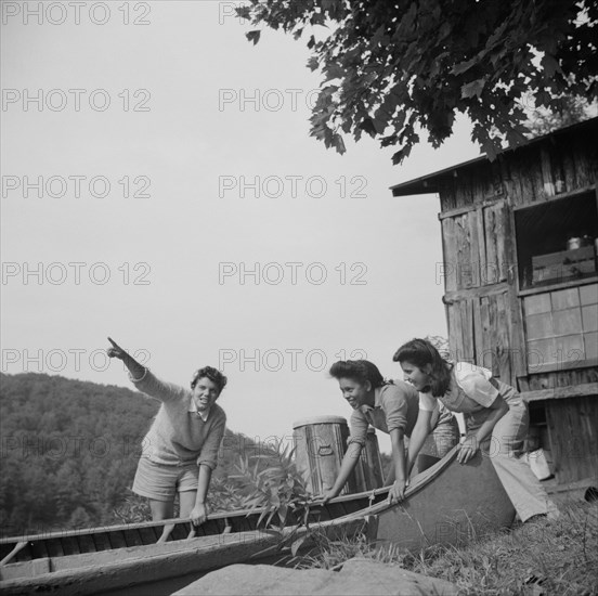 Launching a canoe at Camp Gaylord White, Arden, New York, 1943. Creator: Gordon Parks.