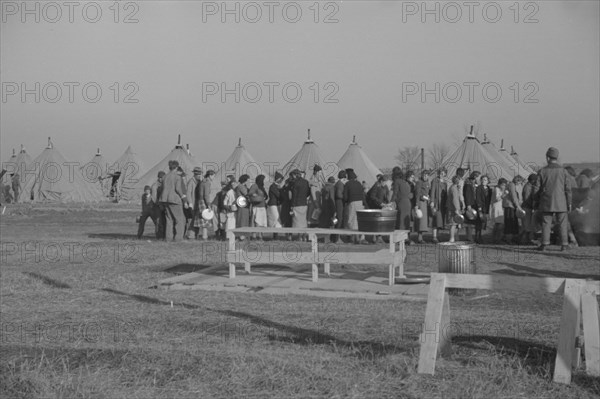 Possibly: Refugees lined up at meal time in the camp for white flood...Forest City, Arkansas, 1937. Creator: Walker Evans.