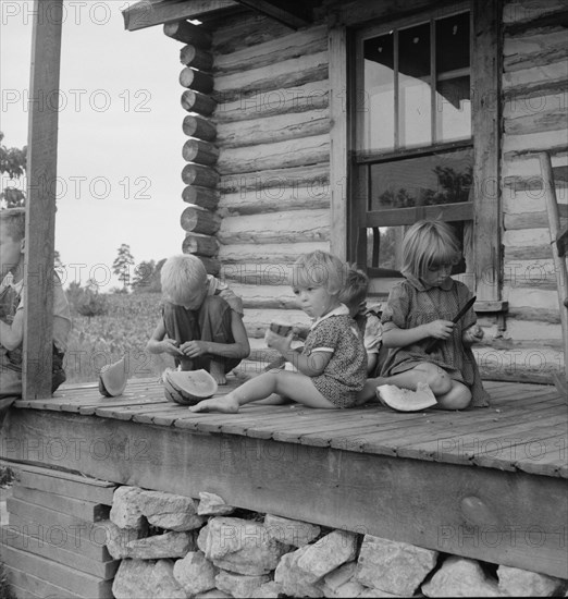 Millworker's children eating watermelon on porch..., Person County, North Carolina, 1939. Creator: Dorothea Lange.