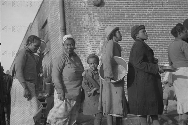 Possibly: Negroes in the lineup for food at the flood refugee camp, Forrest City, Arkansas, 1937. Creator: Walker Evans.