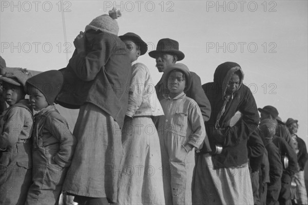 Possibly: Negroes in the lineup for food at the flood refugee camp, Forrest City, Arkansas, 1937. Creator: Walker Evans.