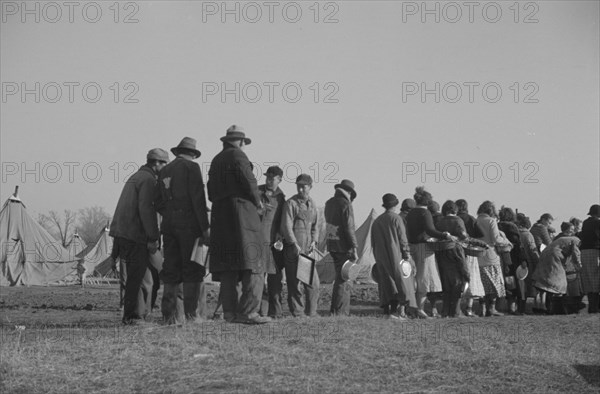 Possibly: Negroes in the lineup for food at the flood refugee camp, Forrest City, Arkansas, 1937. Creator: Walker Evans.