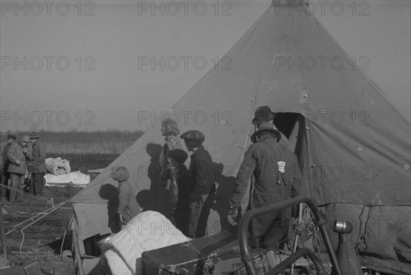 Possibly: Setting up a tent in the camp for white flood refugees, Forrest City, Arkansas, 1937. Creator: Walker Evans.