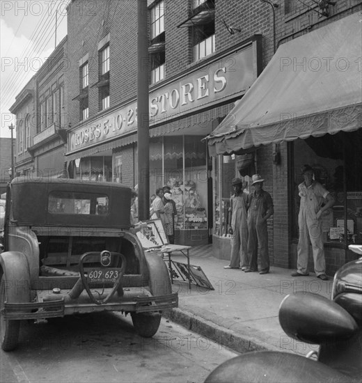 Appliqued embroideries for sale on street in front of ten cent..., Siler City, North Carolina, 1939. Creator: Dorothea Lange.