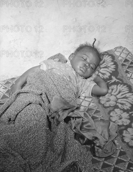 Child seriously ill from an infection caused by a rat bite in her home..., Washington, D.C., 1942. Creator: Gordon Parks.