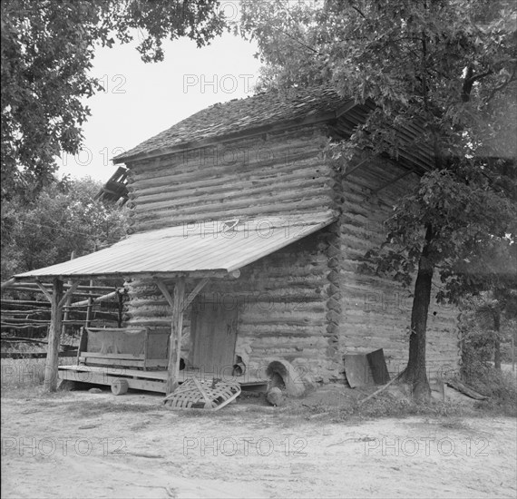 Tobacco barn with tobacco sled and vehicle..., Person County, North Carolina, 1939. Creator: Dorothea Lange.