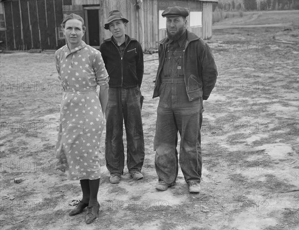 The mother, father, and hardworking fifteen-year-old son in yard..., Boundary County, Idaho, 1939. Creator: Dorothea Lange.