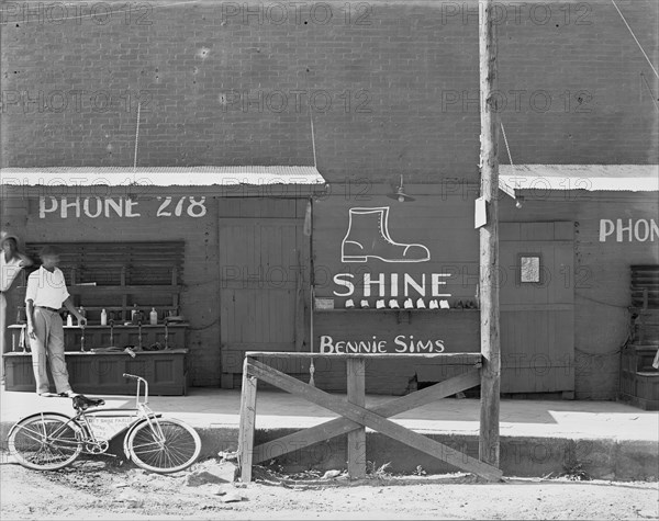 Shoeshine stand, Southeastern U.S. [Sign: 'Shine - Bennie Sims'. On bicycle: City Shine Parlour'].