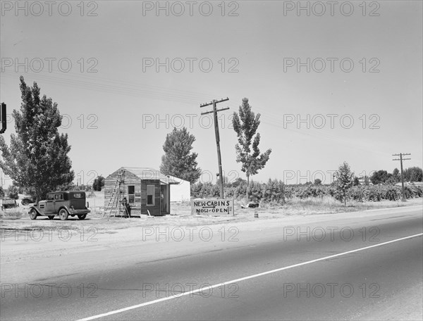 Between Tulare and Fresno, California. [Accommodation for farm workers: 'New  Cabins Now Open'].
