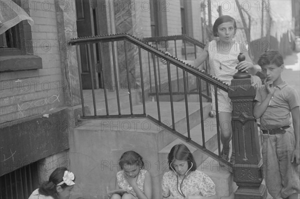 New York, New York. 61st Street between 1st and 3rd Avenues. Children playing in the street.