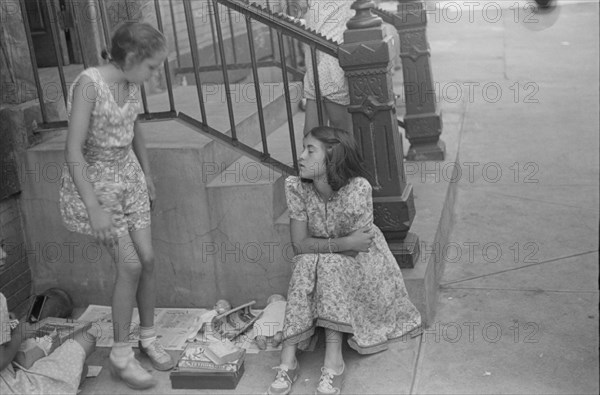 New York, New York. 61st Street between 1st and 3rd Avenues. Children playing in the street.