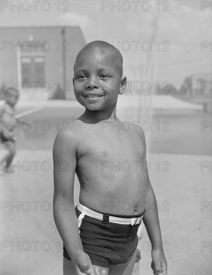 Anacostia, D.C. Frederick Douglass housing project. Cooling off under the community sprayer.