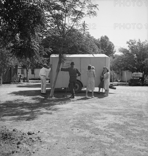 Between Tulare and Fresno on U.S. 99. Family inspect a house trailer with idea of purchase.