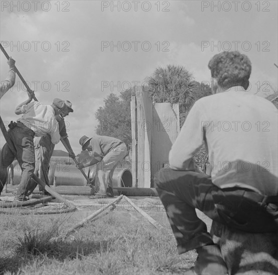 Daytona Beach, Florida. A foreman watching a Negro workman prepare to lay a sewer pipeline.