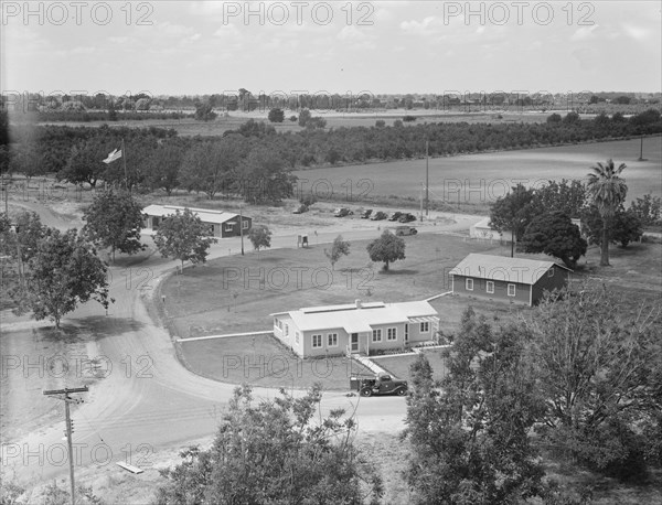 Entrance to camp showing clinic (light building in foreground). Farmersville, California.