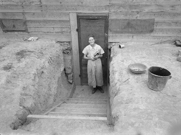 Mrs. Free in doorway of her basement dugout home. Dead Ox Flat, Malheur County, Oregon.