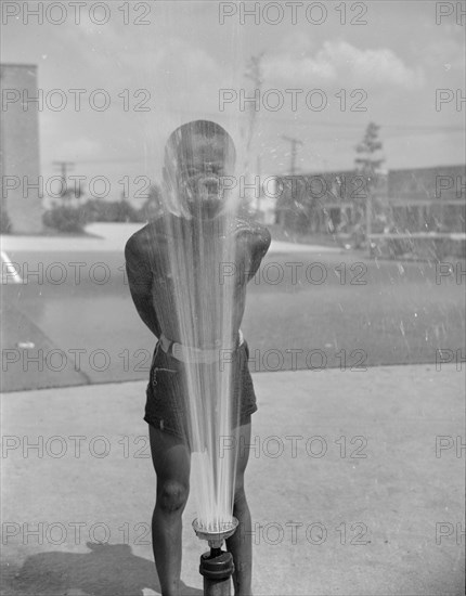 Anacostia, D.C. Frederick Douglass housing project. Playing in the community sprayer.