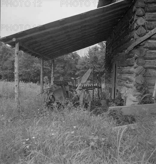 Farm machinery drawn under cover of old tobacco barn. Person County, North Carolina.