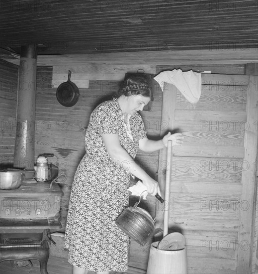 Wife of tobacco sharecropper cleaning butter churn. Person County, North Carolina.