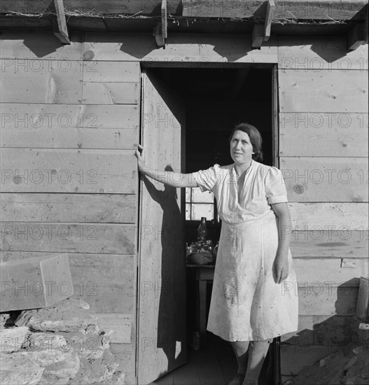 Mrs. Dougherty in doorway of basement house. Warm Springs, Malheur County, Oregon.