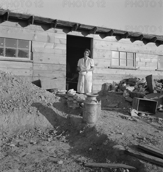 Mrs. Dougherty in doorway of basement house. Warm Springs, Malheur County, Oregon.