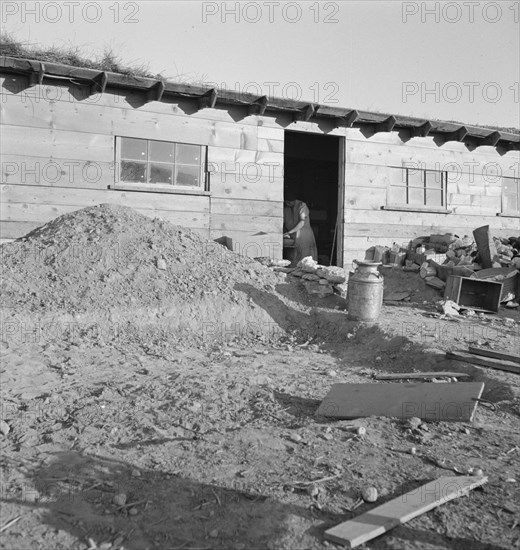 Mrs. Dougherty in doorway of basement house. Warm Springs, Malheur County, Oregon.