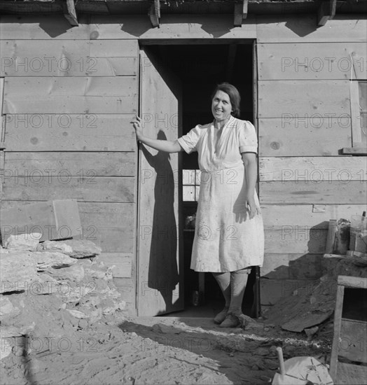 Mrs. Dougherty in doorway of basement house. Warm Springs, Malheur County, Oregon.