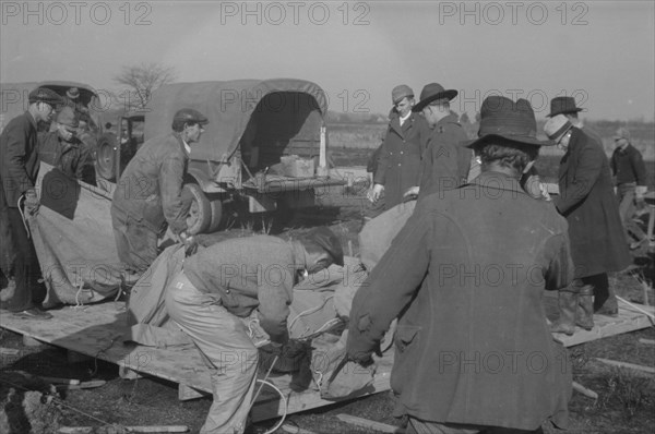 Setting up a tent in the camp for white flood refugees, Forrest City, Arkansas.