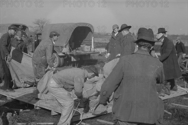 Setting up a tent in the camp for white flood refugees, Forrest City, Arkansas.