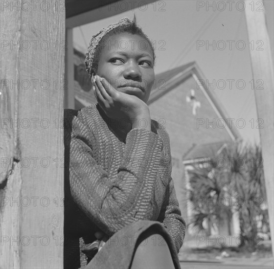 Daytona Beach, Florida. Woman sitting on her porch on Sunday morning.