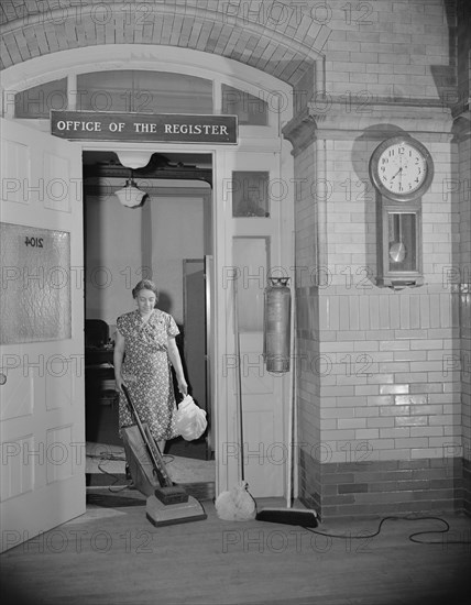 Washington, D.C. Government charwoman cleaning after regular hours.