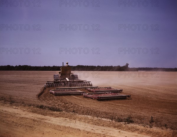 Harrowing a field with a diesel tractor, Seabrook Farm, Bridgeton, N.J., 1942. Creators: Marion Post Wolcott, John Collier.