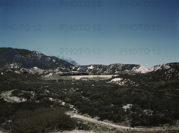 Freight train with two helper engines climbing the steep grade of Cajon Pass (westbound), CA., 1943. Creator: Jack Delano.