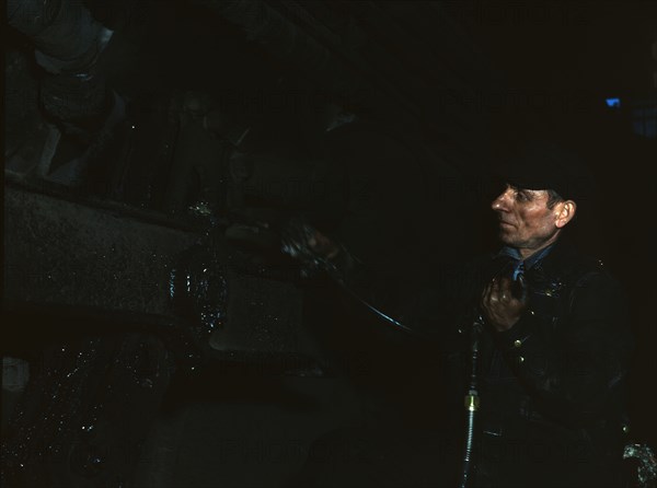 Greasing a locomotive at the 40th Street shops of the C & NW RR, 1942. Creator: Jack Delano.