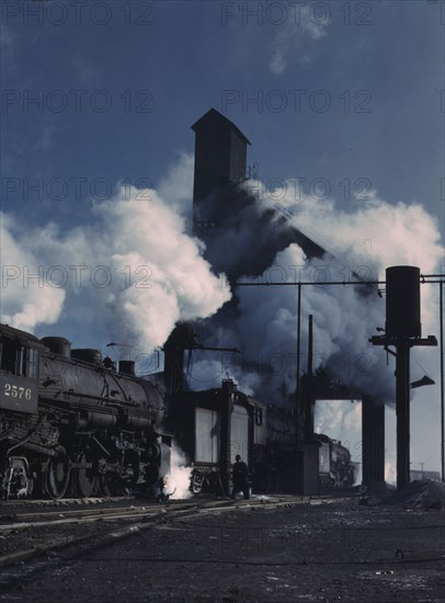 Locomotives over the ash pit at the roundhouse and coaling station...Chicago, Ill., 1942. Creator: Jack Delano.