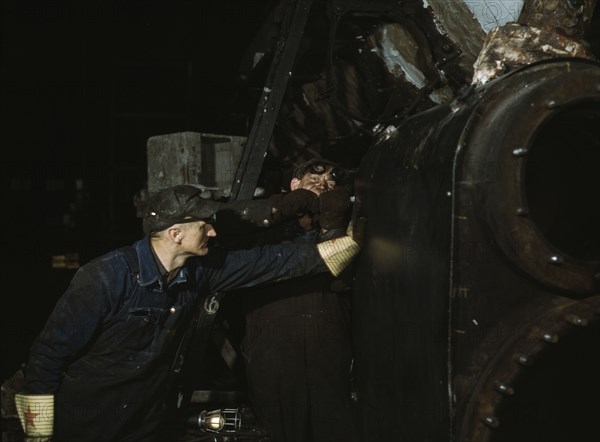 Working on the cylinder of a locomotive at the C & NW RR, 40th Street shops, Chicago, Ill., 1942. Creator: Jack Delano.