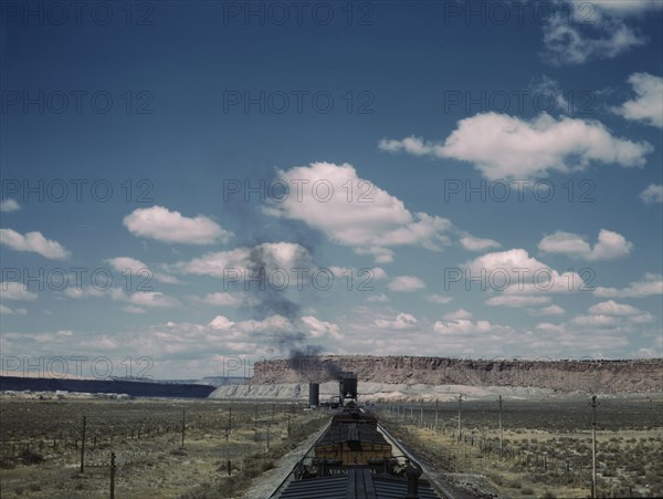 A freight train stopping for coal and water at a siding enroute to Gallup, New Mexico, 1943. Creator: Jack Delano.