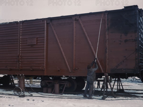 Painting a car at the repair or "rip" tracks at North Proviso(?), C & NW RR, Chicago, Ill., 1942. Creator: Jack Delano.