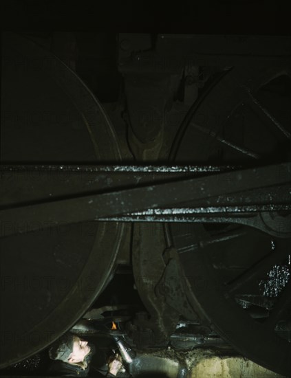 Worker inspecting a locomotive on a pit in the round...C & NW RR's Proviso yard, Chicago, Ill., 1942 Creator: Jack Delano.