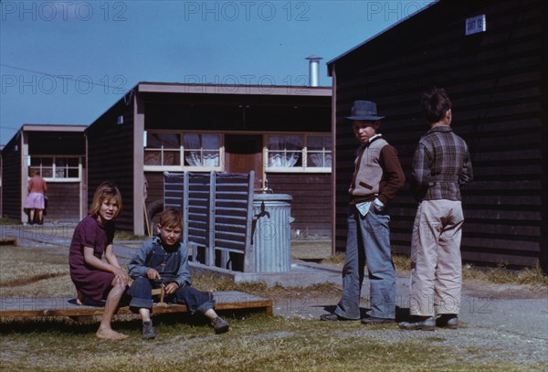 Boy building a model airplane while other children look on, FSA labor camp, Robstown, Tex., 1942. Creator: Arthur Rothstein.