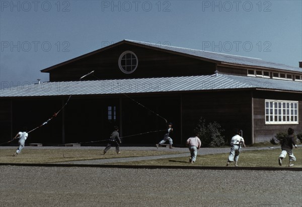 Boys flying a kite in front of community center, FSA ... camp, Robstown, Tex., 1942. Creator: Arthur Rothstein.