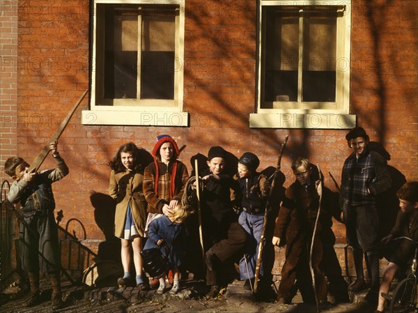 Children aiming sticks as guns, lined up against a brick building, Washington, D.C.?, 1941-1942. Creator: Unknown.