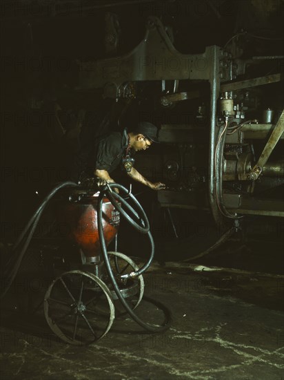 Thomas Madrigal greasing a locomotive in the roundhouse, Rock Island R.R., Blue Island, Ill., 1943. Creator: Jack Delano.