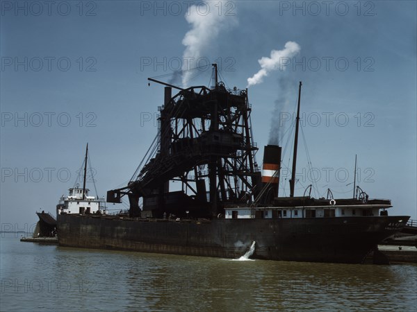 Loading coal into a freighter at one of the Pennsylvania Railroad docks, Sandusky, Ohio, 1943. Creator: Jack Delano.