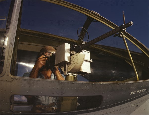 Jesse Rhodes Waller, A.O.M., third class, tries out a 30-calibre...Naval Air Base, Corpus..., 1942. Creator: Howard Hollem.