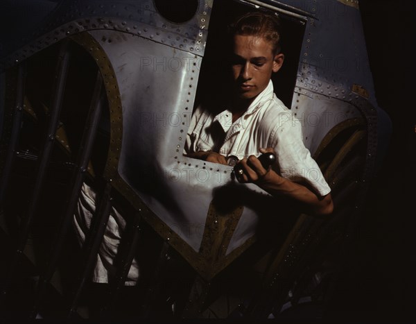 Working inside the nose of a PBY, Elmer J. Pace is learning the...Corus Christi, Texas, 1942. Creator: Howard Hollem.