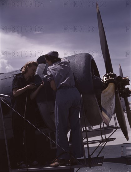 Bowen and Olsen, a riveter and her supervisor, in the...Naval Air Base, Corpus Christi, Texas, 1942. Creator: Howard Hollem.